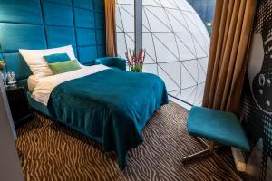 布尔诺索诺酒店的一间卧室配有蓝色的床和椅子