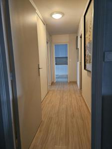 安纳马斯Chambre d'hôte - hypercentre的走廊设有通往木地板客房的门