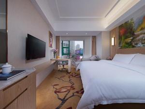 重庆Vienna Hotel Chongqing Jiefangbei Hongyadong的酒店客房设有一张大床和一台电视。