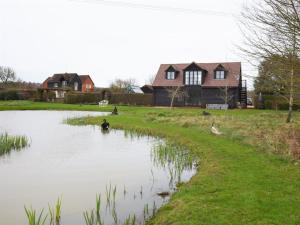 Rudgwick1 Bed in Horsham 86961的一座房子前面的池塘,里面有鸭子