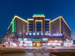 BaigaonongchangGreen Tree Inn Zhuhai International Airport Huafa Shangdu的前面有绿灯的大建筑