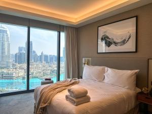 迪拜Luxury 3-bedroom apartment with a stunning view of the Burj Khalifa and the Fountain的一间卧室设有一张床和一个大窗户