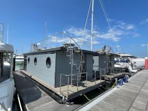 雅茅斯Yarmouth Waterlodge Floating Apartment 1的船停靠在码头