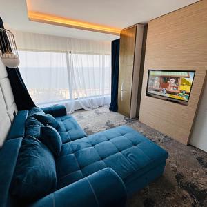 奥林普STEAUA DE MARE - Olimp Resort的配有大窗户的客房内的蓝色沙发