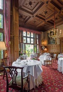 陶努斯山区克龙贝格克伦贝格城堡酒店 - 法兰克福酒店的一间带桌椅和吊灯的用餐室