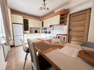 弗罗茨瓦夫ARTHOME的厨房配有木桌和白色橱柜。