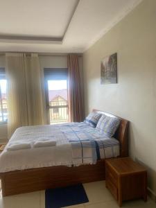 基加利ADRIEL HOMES KIGALi的一间卧室设有一张床和一个窗口
