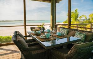Mangrove CayVilla Blue Hole的海滩景门廊上的餐桌
