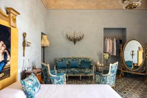 托雷德尔格雷科Villa De Cillis Carafa的一间卧室配有一张床、一把椅子和镜子