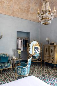 托雷德尔格雷科Villa De Cillis Carafa的一间带椅子、镜子和吊灯的房间