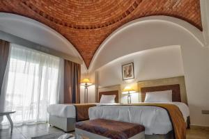 马萨阿拉姆Amarina Queen Resort Marsa Alam的酒店客房设有两张床和大窗户。