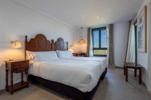扎哈拉Hotel Tugasa Arco de la Villa的一间卧室设有一张大床和一个大窗户