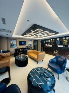 伊斯坦布尔Aprilis Gold Hotel - Special Category的客厅配有沙发、椅子和桌子