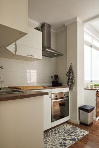 埃尔切Low Cost Apartments Center Elche的厨房配有白色橱柜和炉灶。