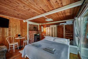 KismarosOlive Tree Forest Cabin Original的一间卧室配有一张床和一张桌子及椅子