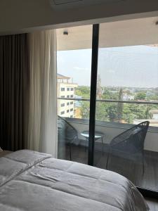 阿克拉Solaris Premium Luxury Living的一间卧室设有一张床和一个大窗户