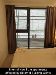 布里斯托克雷罗服务公寓酒店 - 芬泽尔斯里奇的一间卧室设有一张床和一个大窗户
