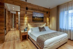 阿夏戈Asiago Sporting Hotel & Spa的一间卧室设有一张床和木墙