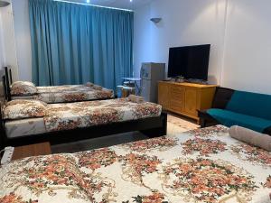 阿布扎比J & F Homestay - Abu Dhabi的酒店客房设有两张床和电视。