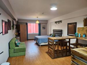 利马Alojamiento San Francisco Espaciosos y lindos mini apartamentos的一间卧室配有一张床铺和一张桌子,还设有一间厨房