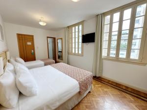 里约热内卢蒙特阿尔格力酒店的卧室设有白色大床和窗户。