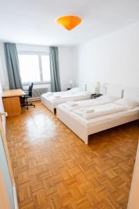 维也纳Central Living Apartments - Staatsoper的一间卧室配有两张床、一张桌子和一张桌子