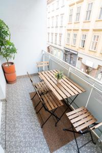 维也纳Central Living Apartments - Staatsoper的阳台上的木桌和椅子