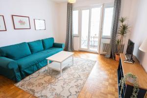 维也纳Central Living Apartments - Staatsoper的客厅配有蓝色的沙发和桌子