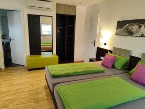 腓特烈港Hotel Stock Bäckerstüble的绿粉色客房的两张床