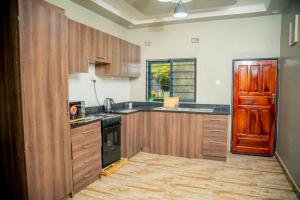 卢萨卡Kamps Apartment - Foxdale Forest的厨房配有木制橱柜和黑炉。