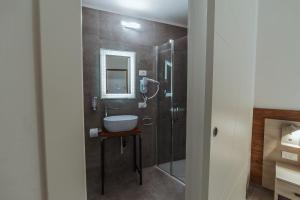 雷扎托Hotel Alla Sosta的一间带水槽和淋浴的浴室