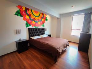 库斯科Magic Packer Hostel的一间卧室配有一张壁画床