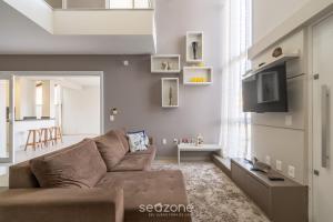 皮萨拉斯Casa de 2 pisos a 110m da praia em Piçarras SAP260的客厅配有棕色沙发和电视