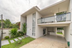 皮萨拉斯Casa de 2 pisos a 110m da praia em Piçarras SAP260的带阳台的大型白色房屋