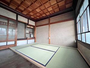 高山Hostel Miyagawa by Murasaki Ryokan的一间空房间,房间带桌子,房间带窗户
