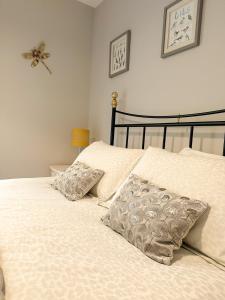 比灵斯赫斯特Dragonfly Lodge Ifold & Alpaca My Tipi Glamping的一张带两个枕头的床和墙上的蜘蛛