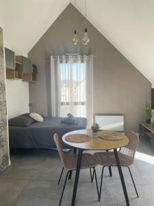 朗西厄Studio avec terrasse proche de la mer的卧室配有一张床和一张桌子及椅子