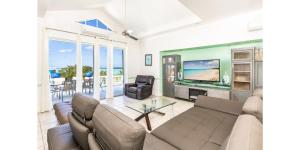 普罗维登西亚莱斯岛NEW Waterside Home Whirlpool Spa Tub Smart TV的带沙发和电视的客厅
