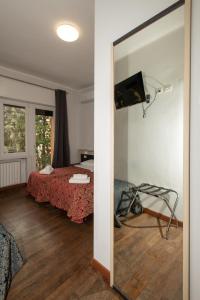 米兰乔亚别墅酒店的客房设有一张床、镜子和电视