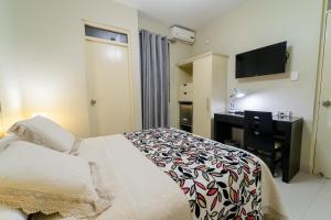 皮乌拉厄尔普林西酒店的一间卧室配有一张床、一张书桌和一台电视