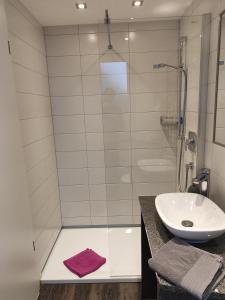 腓特烈港Hotel Stock Schokotöpfle的一间带玻璃淋浴和水槽的浴室