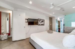 圣地亚哥Kettner Row 1的白色卧室设有一张大床和一台平面电视。