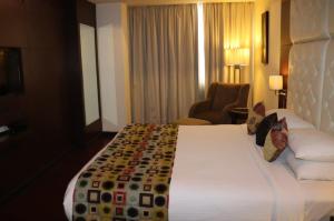 ChirāwaSangam Hotel Marriage Garden & Restaurant的酒店客房带一张大床和一把椅子