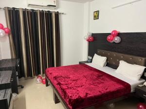 古尔冈Staykr Rooms & BnB的一间卧室配有一张带红色毯子和气球的床。