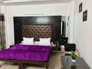 古尔冈Staykr Rooms & BnB的一间卧室配有一张紫色的床和一把椅子