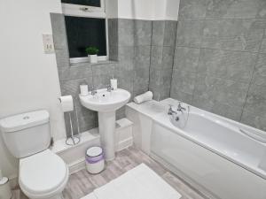 斯陶尔波特Charming Home in Stourport Sleeps10 with Wifi&Parking by PureStay Short Lets的浴室配有卫生间、盥洗盆和浴缸。