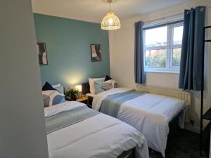 斯陶尔波特Charming Home in Stourport Sleeps10 with Wifi&Parking by PureStay Short Lets的带窗户的客房内的两张床
