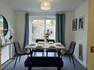 斯陶尔波特Charming Home in Stourport Sleeps10 with Wifi&Parking by PureStay Short Lets的一间带桌椅和窗户的用餐室