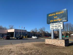 奥尔巴尼Albany Airport Inn的停车场前的标志