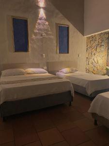 圣玛尔塔EcoHotel Inka Minka的一间卧室设有两张床和两个窗户。